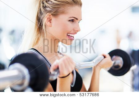 Woman in gym lifting weights