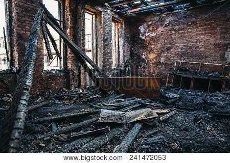 Ruins Of Burned Brick House After Fire Disaster Accident. Heaps Of Ash And Arson, Burnt Furniture, C