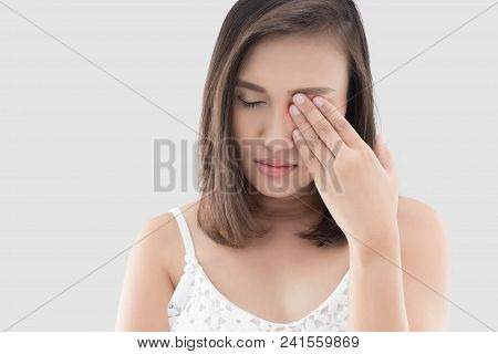 Asian Woman Suffering From Strong Eye Pain Against Gray Background. Female Has A Pain In The Eye. He