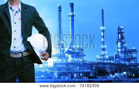 Engineering Man And Safety Helmet Standing Against Oil Refinery Plant In Heavy Petrochemical Industr