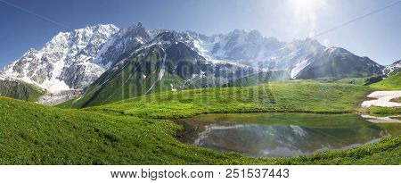 Mountain Landscape Of Svaneti On Bright Summer Sunny Day. Mountain Lake, Hills Covered Green Grass O