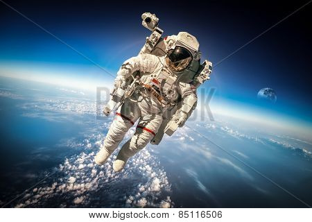 Astronaut in outer space against the backdrop of the planet earth. Elements of this image furnished by NASA.