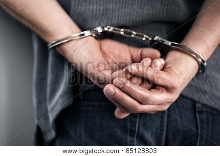 Arrested man in handcuffs with hands behind back