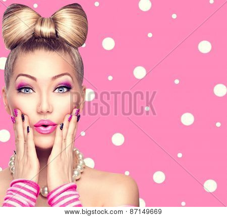 Beauty Surprised fashion model girl with funny bow hairstyle, pink nail art and makeup over polka dots background. Colourful Studio Shot of Funny Woman. Vivid Colors. Emotion