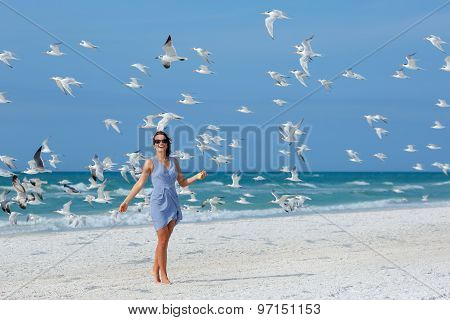 Young beautiful woman watching the seagulls flying