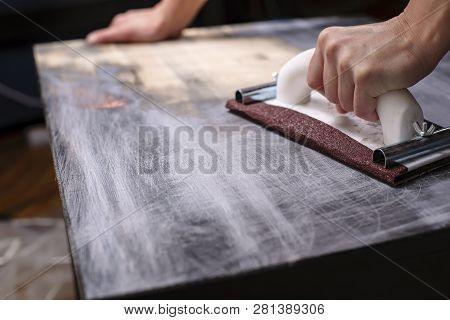 Person Prepares The Surface For Painting And Sanding By Hands An Old Wooden Black Table With A Manua