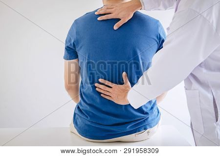 Doctor Physiotherapist Treating Lower Back Pain Patient After While Giving Exercising Treatment On S