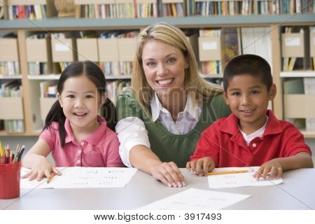 Dois alunos em classe com o professor