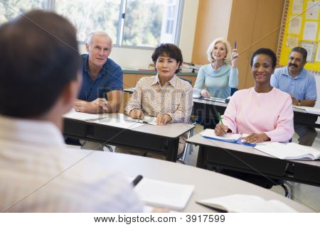 Estudantes adultos na classe com o professor (foco seletivo)