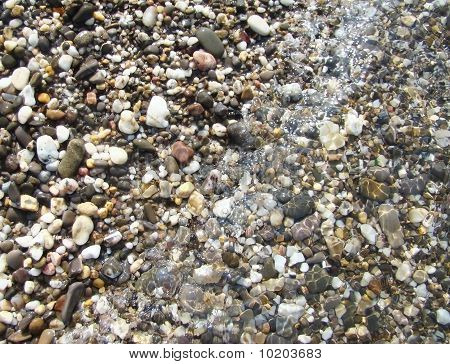 Background.Pebble em uma praia na água do mar