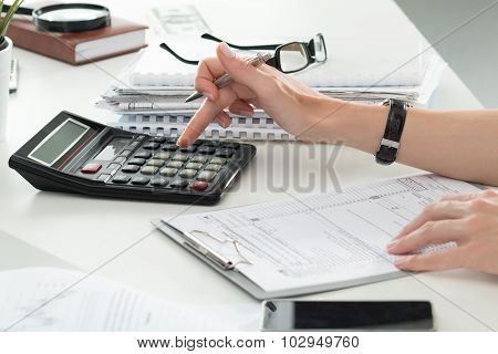 Close Up Of Female Accountant Or Banker Making Calculations