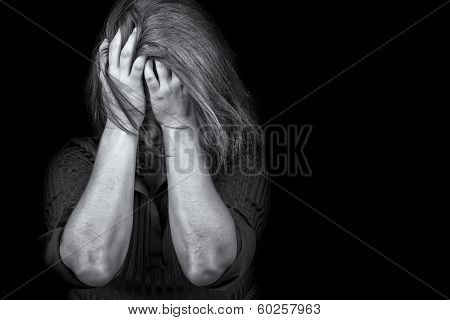 Black and white image of a young woman crying useful to illustrate stress, depression or domestic violence