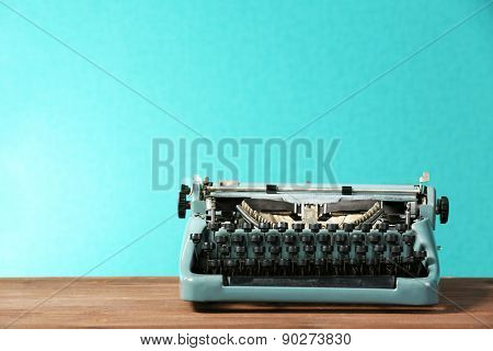 Old retro typewriter on table on green background