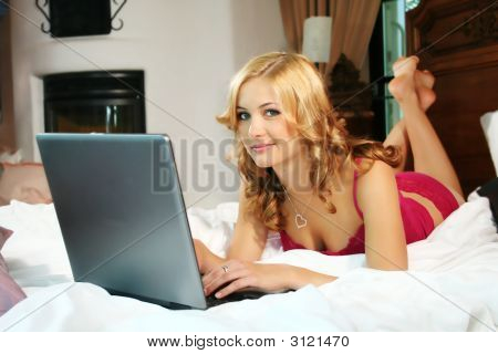 Vrouw met een Laptop In haar Bed