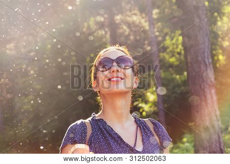 Beautiful Woman Smiling In Nature. Happy People Lifestyle. Woman Smiling In Sunshine With Water Drop