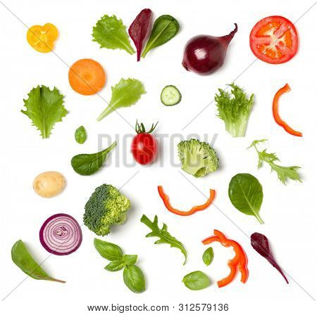 Creative layout made of tomato slice, onion, cucumber, basil leaves. Flat lay, top view. Food concept. Vegetables isolated on white background. Food ingredient pattern.