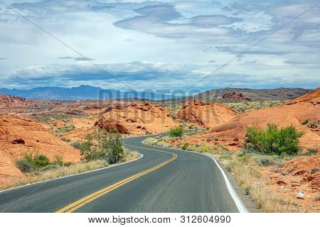 Long Winding Highway With Ups And Downs, Cloudy Blue Sky. Valley Of Fire Nevada, Usa