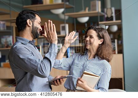 Two Happy Friendly Diverse Professionals, Teacher And Student Giving High Five Standing In Office Ce