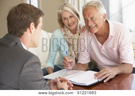 Senior Couple Meeting With Financial Advisor At Home