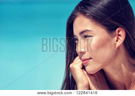 Young Asian beauty woman face closeup portrait. Mixed race Chinese Caucasian girl profile with healthy glowing skin and natural makeup on cheeks, eyelids, eyebrows, lips. Skincare concept.