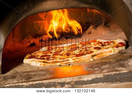 Fresh original Italian pizza in a traditional wood-fired stone oven.