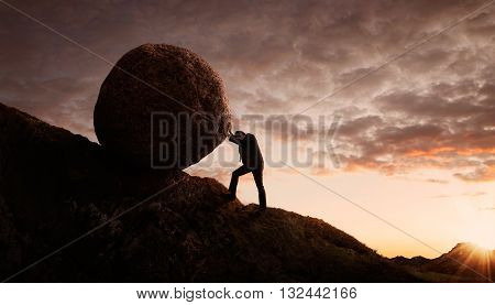 Business concept Young businessman pushing large stone uphill with copy space