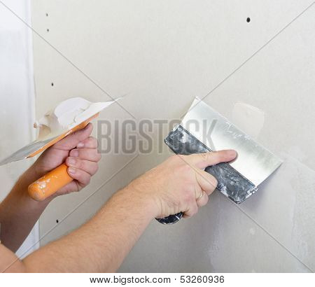 repairman works with plasterboard, plastering dry-stone wall, home improvement