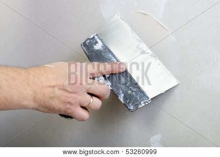 repairman works with plasterboard, plastering dry-stone wall, home improvement