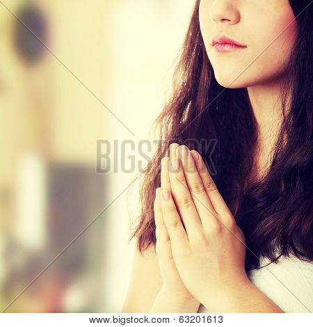 Closeup portrait of a young caucasian woman praying