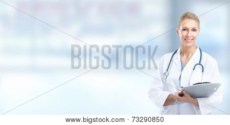 Beautiful smiling doctor woman over blue hospital background