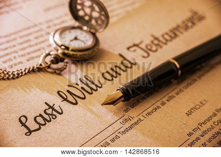 Vintage / retro style with a long shadow : Fountain pen a pocket watch on a last will and testament. A form is printed on a mulberry paper and waiting to be filled and signed by testator / testatrix.