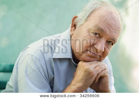 Portrait Of Sad Bald Senior Man Looking At Camera