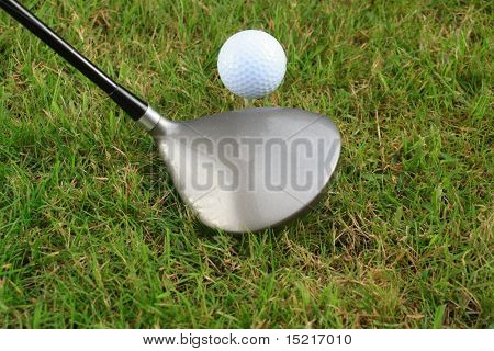 Driver or one wood and a golf ball on a tee peg on the teeing ground.