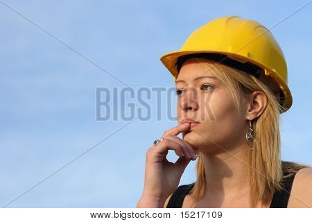 Young female architect apprentice with yellow hard hat.