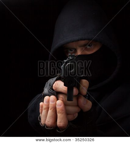 Masked Robber With Gun Aiming Into The Camera