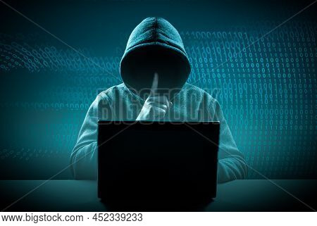 Faceless Hooded Hacker Showing Silence Gesture. Hacker Attack. Dangerous Hooded Hacker Breaks Into G