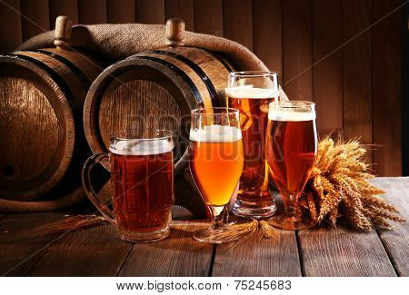 Beer barrel with beer glasses on table on wooden background