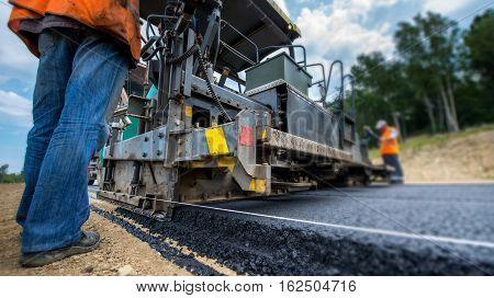 Paving new road with asphalt, road construction