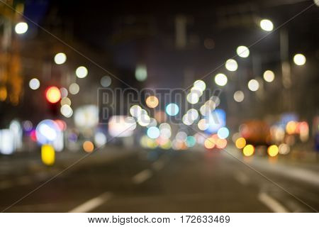 Night city view in blur. City street blurry photo. Streetlife bokeh image. Street view with pedestrians and cars defocused image. Road in big city bokeh image. Night city lifestyle blurry background