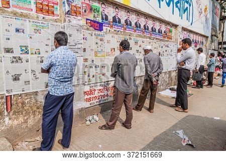 Dhaka, Bangladesh - November 20, 2016: People Are Reading Daily Newspaper Published On A Wall In Dha