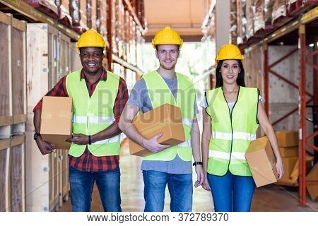 Portrait of caucasian white and african black warehouse workers hold cardboard box packaging in warehouse distribution center environment. Using in business warehouse diversity and logistic concept.