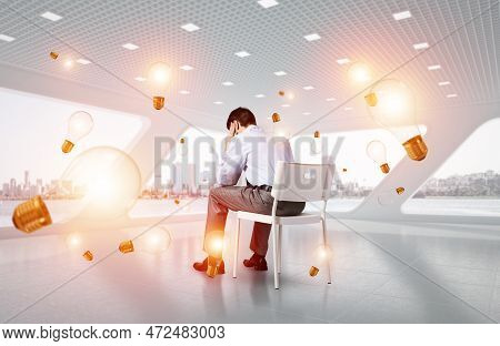 Young Businessman Sitting On A Chair With His Head In His Hands