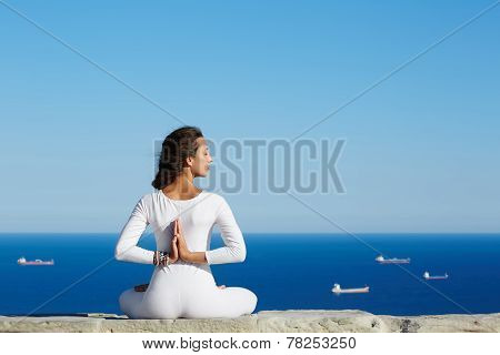 Woman seated in yoga pose on amazing sea background woman meditating yoga enjoying sunny evening