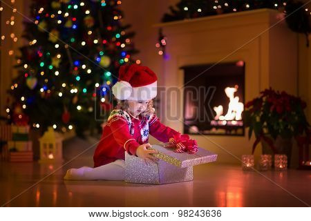 Kids Opening Christmas Presents At Fireplace