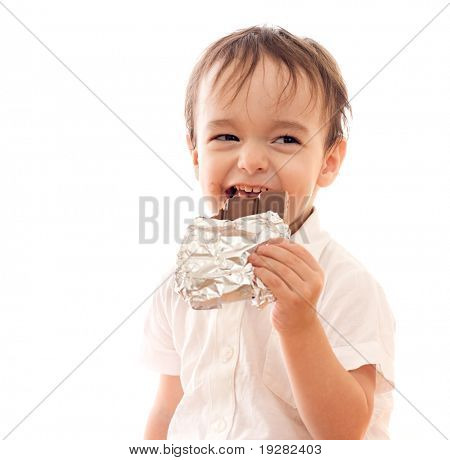 Happy little boy with bar of chocolate in his hand