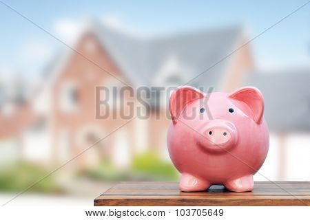 Saving to buy a house, real estate or home savings, piggy bank in front of property