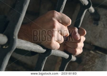 hands grabbing prison bars