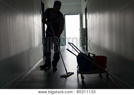 Man With Broom Cleaning Office Corridor