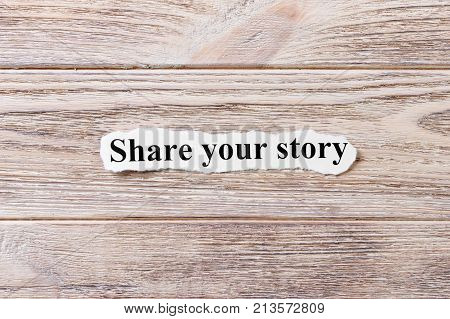 Share your story of the word on paper. concept. Words of Share your story on a wooden background.