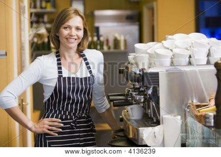 Mulher fazendo café no restaurante sorrindo